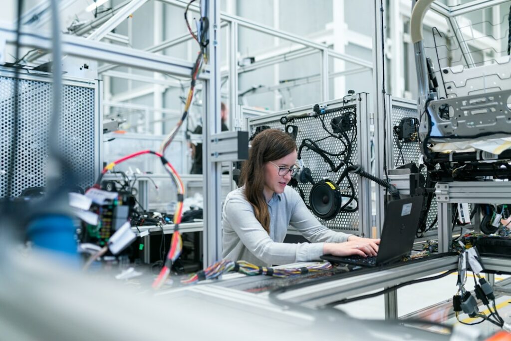 Ingeniera utilizando inteligencia artificial y datos en un entorno industrial de fabricación